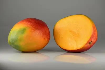 A whole mango and a halved one
